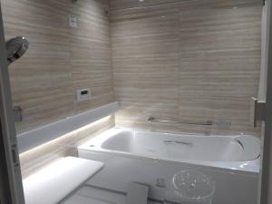 y baño con bañera blanca y aseo. en duckweed - Vacation STAY 52571v, en Tone