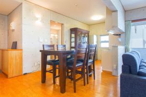 a dining room with a wooden table and chairs at New Life Mansion 101 - Vacation STAY 57160v in Fuzuchi
