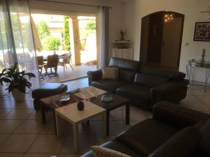 ein Wohnzimmer mit einem Sofa und einem Tisch in der Unterkunft Maison avec piscine et vue sur les collines. in Marseille