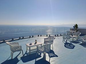 a patio with tables and chairs and the ocean at B&b La Luna sul Mare - Sea & Spa in Casteldaccia