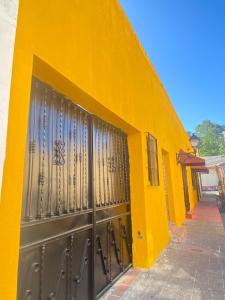 un edificio amarillo con puertas metálicas de garaje. en Apartamentos Colonial Sanchez 264, en Santo Domingo