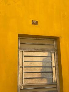 pared amarilla con puerta de garaje con ventana en Apartamentos Colonial Sanchez 264, en Santo Domingo