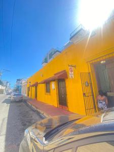 un edificio amarillo al lado de una calle en Apartamentos Colonial Sanchez 264, en Santo Domingo