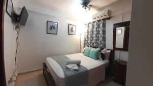 Dormitorio pequeño con cama y TV en Apartamentos Colonial Sanchez 264, en Santo Domingo