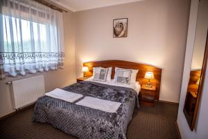 a hotel room with a bed and a window at Nad Zatoką in Bryzgiel