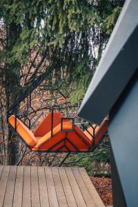 eine Gruppe orangefarbener Stühle unter einem Baum in der Unterkunft Armadillo Houses in Kopaonik