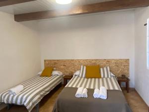 a bedroom with two beds with towels on them at Casa Pastor, Delta del Ebro in El Lligallo del Gànguil