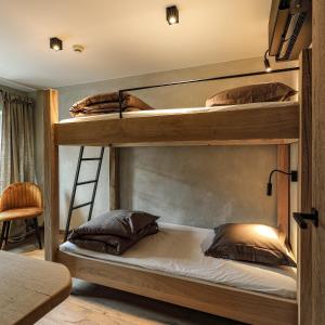 2 stapelbedden in een kamer met een ladder bij Couleur basilic in Rochefort