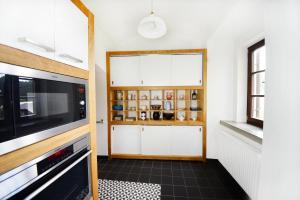 cocina con armarios blancos y microondas en Fara Rejštejn, en RejÅ¡tejn