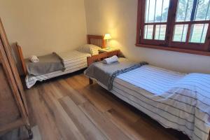 a bedroom with two beds and a lamp on a wooden floor at Casa de campo Don Juan in Duggan +16 photos