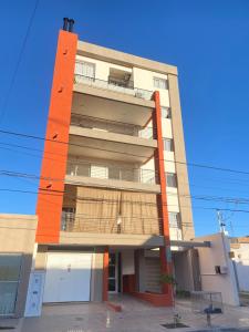 a tall building with an orange at Apartamento a metros de la costanera y el lago in Villa María