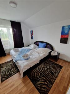 - un grand lit dans une chambre avec un tapis dans l'établissement Casa Camelia, à Ocna Şugatag