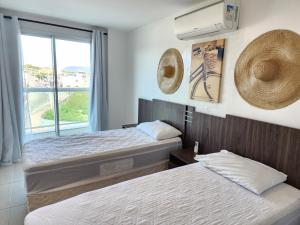 Habitación de hotel con 2 camas y ventana en PACIFIC - PRAIA DO FORTE, en Cabo Frío