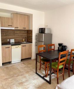 - une cuisine avec une table et des chaises dans la chambre dans l'établissement Studio Coin nuit 205 Résidence Les Acacias, à Anduze