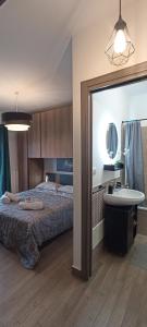 1 dormitorio con cama, lavabo y espejo en GreenHouse, en Casale Smeraldi