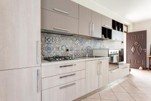 uma cozinha com armários brancos e um forno com placa de fogão em Apartment MisiAdele em Carnago