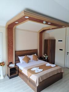 Perla Blanca Hotel في طرابزون: غرفة نوم مع سرير كبير مع مرآة كبيرة فوقها