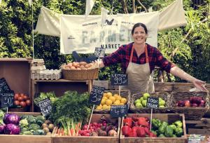 una mujer parada frente a un puesto de frutas y hortalizas en Beautiful 5-bedroom private house in quiet London street 2 minutes from station en Londres