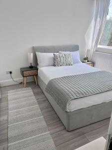 een slaapkamer met een bed en een raam bij Beautiful 5-bedroom private house in quiet London street 2 minutes from station in Londen