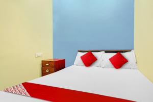 a bedroom with a bed with red and white pillows at OYO Flagship 81098 Hotel Uniq in Bhilai