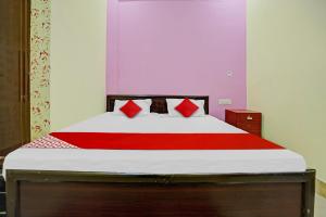 a bedroom with a bed with a red blanket at OYO Flagship 81098 Hotel Uniq in Bhilai