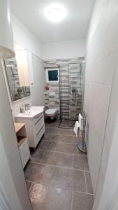 ein Badezimmer mit Dusche, Waschbecken und Toilette in der Unterkunft Tonka in Vodice + 15 Fotos