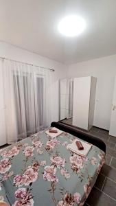 a bedroom with a bed with a blanket with flowers on it at Tonka in Vodice