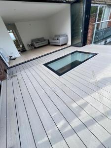 a patio with a glass pool on a wooden deck at Beautiful 5-bedroom private house in quiet London street 2 minutes from station in London