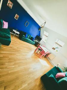 una sala de estar con paredes azules y sofás verdes en Top Roof ApARTment, en Gdansk