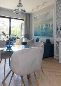 een woonkamer met een bank en een tafel met stoelen bij SHELLTER Apartament Blue Dune-Rogowo in Rogowo