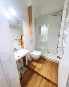 y baño con ducha, aseo y lavamanos. en Gdynia Główna Apartments, en Gdynia