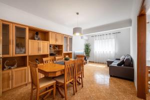 uma cozinha e sala de jantar com uma mesa de madeira e cadeiras em Porto Santo Apartment na Nazaré