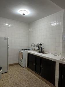 a kitchen with a sink and a stove at Apart Centro- VICTORIA555 in Libertador General San Martín