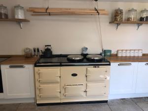 a kitchen with a stove and white cabinets at Lanehead Old School in Lanehead