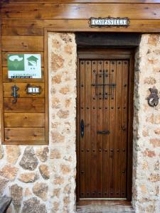 una puerta de madera de un edificio con una pared de piedra en Casa Rural Campanilla en Riópar
