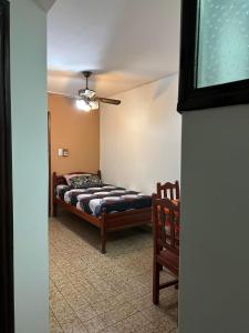 a bedroom with a bed and two chairs at Apart Centro- VICTORIA555 in Libertador General San Martín