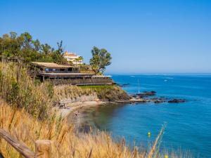 a house on a hill next to the ocean at Cubo's Beach Front Villa Benalmadena in Torremuelle