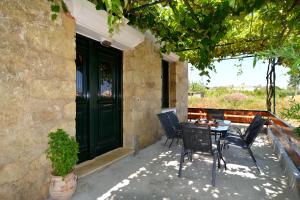 a patio with a table and chairs and a green door at Erietas House in Chania Town