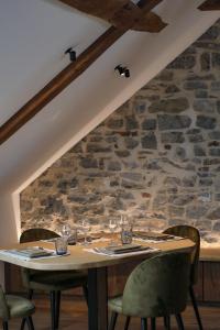 une table dans une pièce avec un mur en pierre dans l'établissement Couleur basilic, à Rochefort