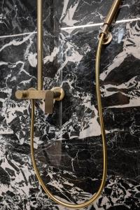 une salle de bains pourvue d'une douche avec une poignée d'or dans l'établissement Villa Activitas - Professional Fitness & Pool, à Kaštela