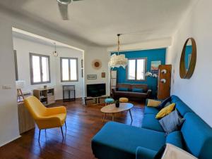 un salon avec un canapé bleu et un fauteuil jaune dans l'établissement Loft 80m2 Bandol dernier étage à 100m plage, centre, port, à Bandol