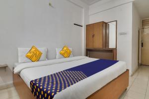 - une chambre dotée d'un grand lit avec des oreillers jaunes et bleus dans l'établissement SPOT ON Apsara Hotel, à Hyderabad