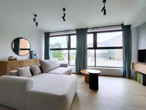 a living room with a couch and a large window at Turnau City Aparthotel in Kraków