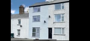 a white house with white windows and a door at Leerick Cottage in Conwy