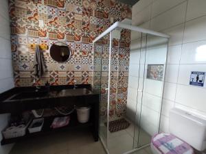 a bathroom with a sink and a mirror at Apto próximo a Lagoa do Ibiraquera in Garopaba