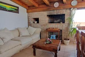 ein Wohnzimmer mit einem Sofa und einem gemauerten Kamin in der Unterkunft La terrazza sul golfo in Sìnnai