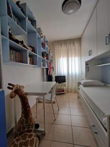Zimmer mit einem Bett, einem Schreibtisch und einem Giraffenspielzeug in der Unterkunft La terrazza sul golfo in Sìnnai