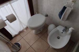 ein Badezimmer mit einem weißen WC und einem Waschbecken in der Unterkunft La terrazza sul golfo in Sìnnai