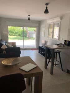 sala de estar con mesa y cocina en Mougere des oliviers, en Galargues