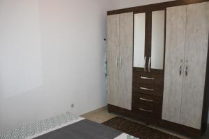 - une chambre avec une armoire en bois et un lit dans l'établissement L'hibiscus - Proche centre de Cayenne, à Cayenne